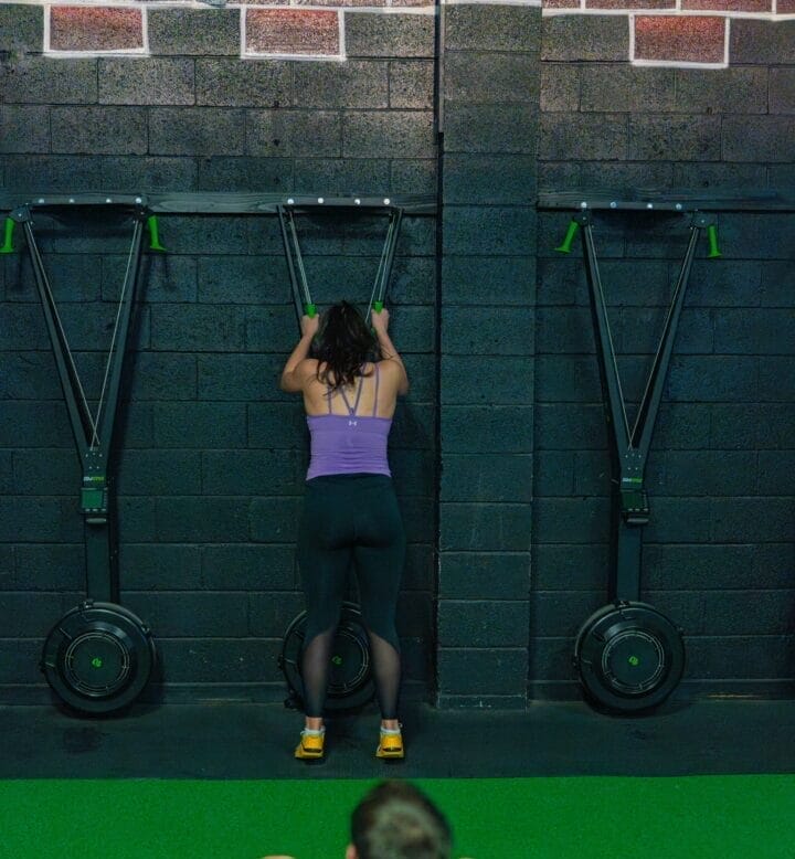 Woman using a ski erg in a Hyrox class.