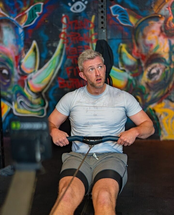 Man on a rower in a HYROX class