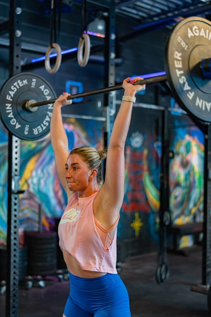 Woman doing overhead press at UltiMET Fitness.